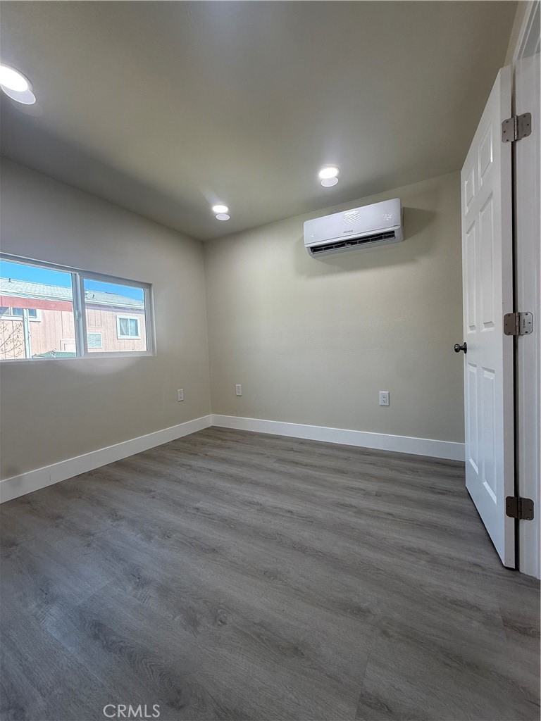 7700 Lampson Avenue, Unit 52 Garden Grove, CA 92841 - Photo 9 of 11 an empty room with wooden floor and windows