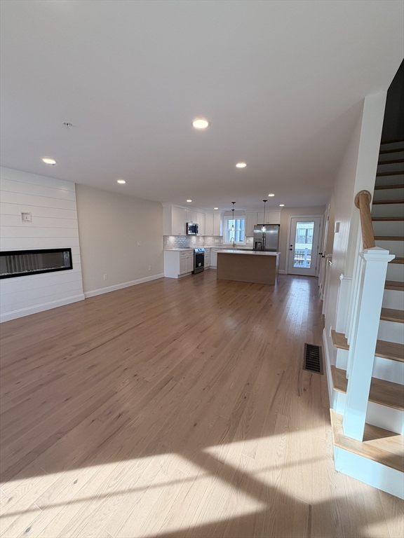 9 Acton Road, Unit 10 Chelmsford, MA 01824 - Photo 13 of 15 a view of open kitchen with wooden floor and chairs