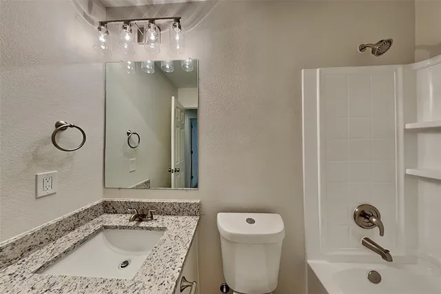 a bathroom with a sink a toilet and shower a mirror