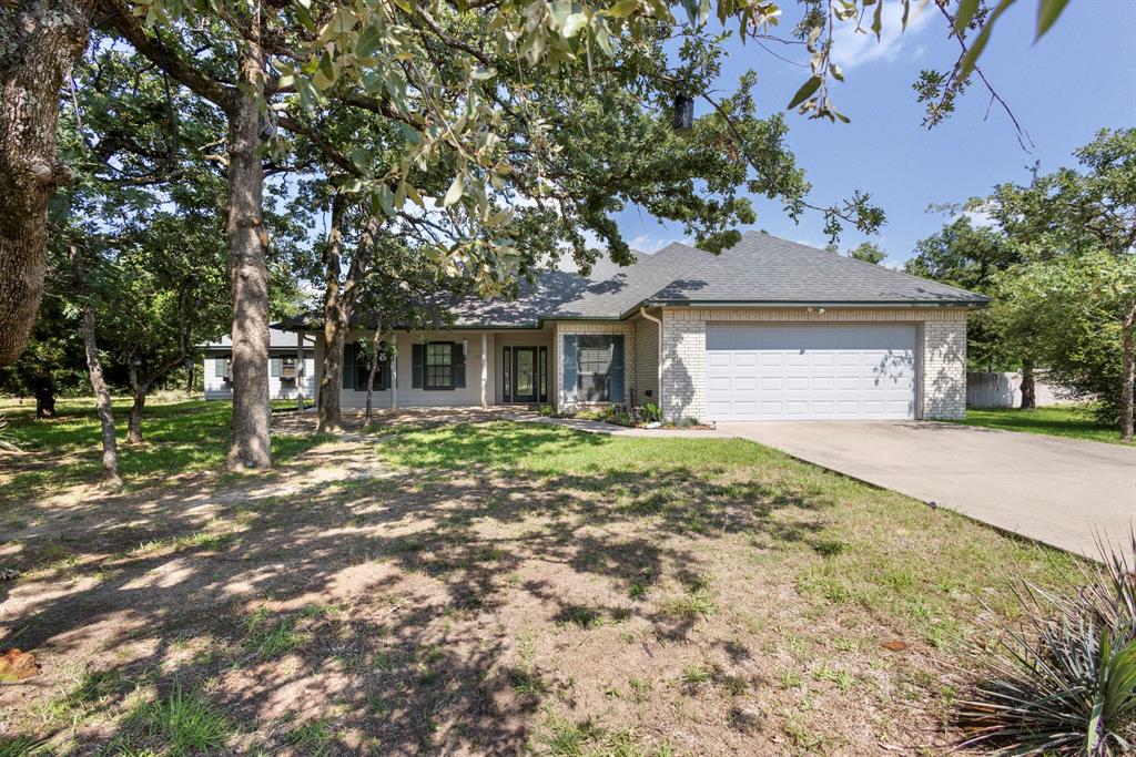 Ranch-style house featuring a garage, brick siding, concrete driveway, and a shingled roof