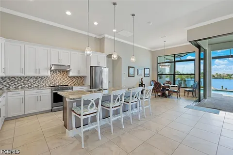 a dinning area with granite countertop a stove a sink a dining table and chairs