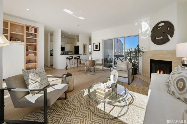 a living room with furniture a fireplace and dining table
