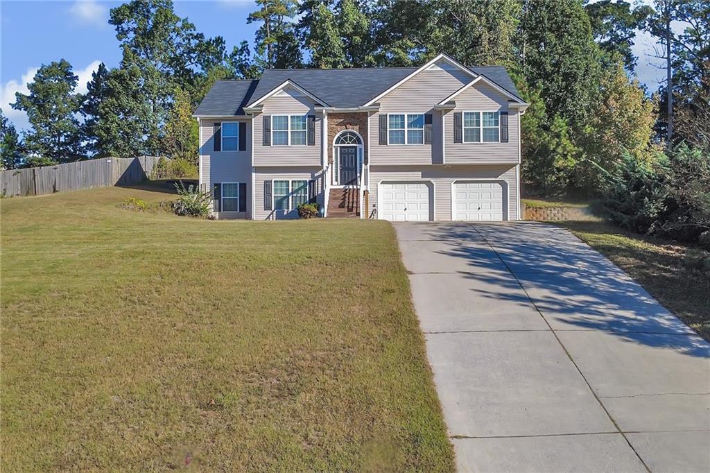 a front view of a house with yard and large trees