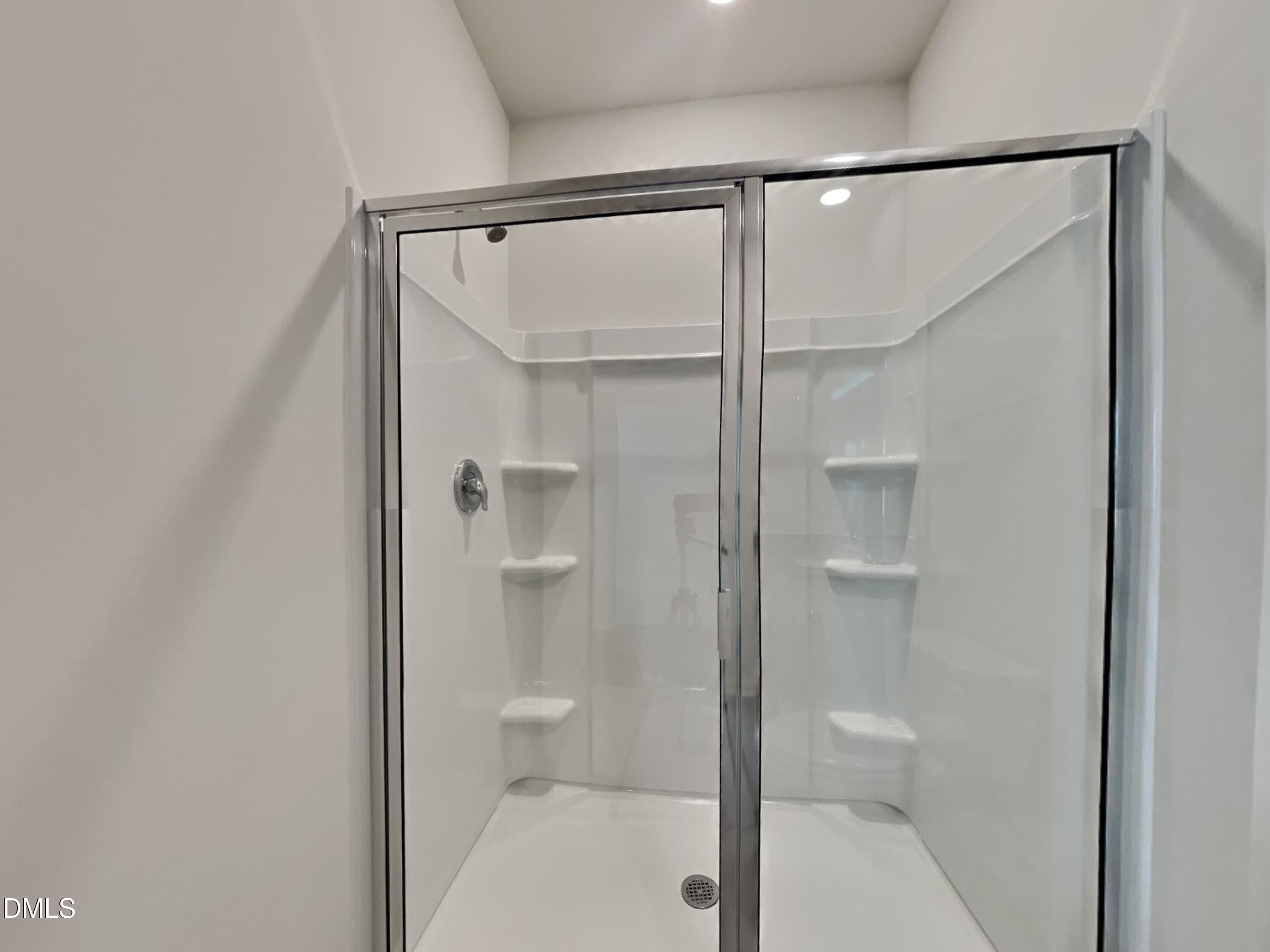 141 Chapel Drive Fuquay-Varina, NC 27526 - Photo 12 of 18 a bathroom with a glass shower door