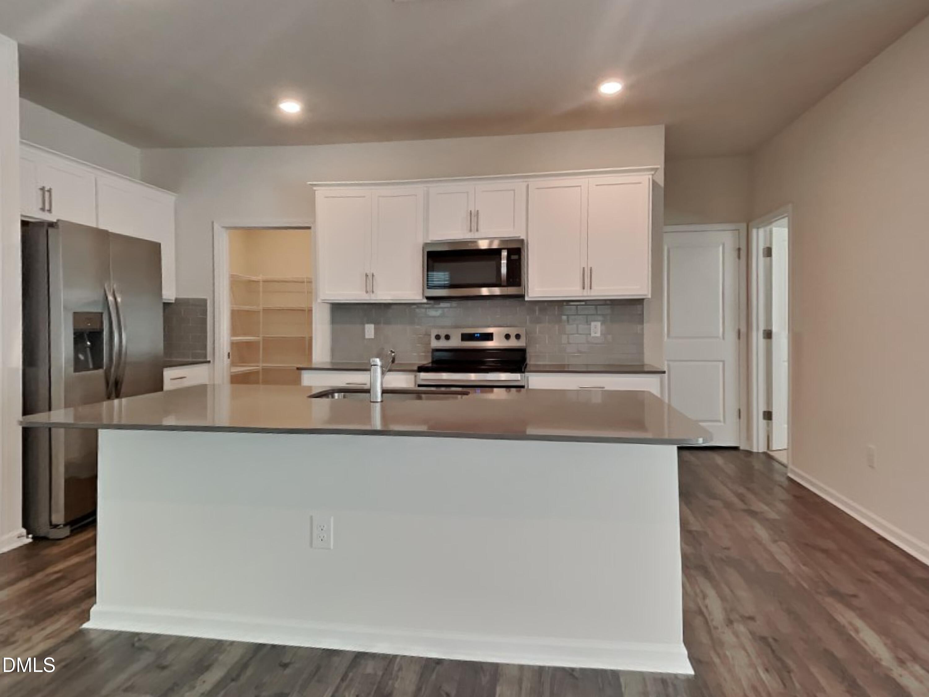141 Chapel Drive Fuquay-Varina, NC 27526 - Photo 3 of 18 a large kitchen with stainless steel appliances granite countertop a stove a sink and a refrigerator