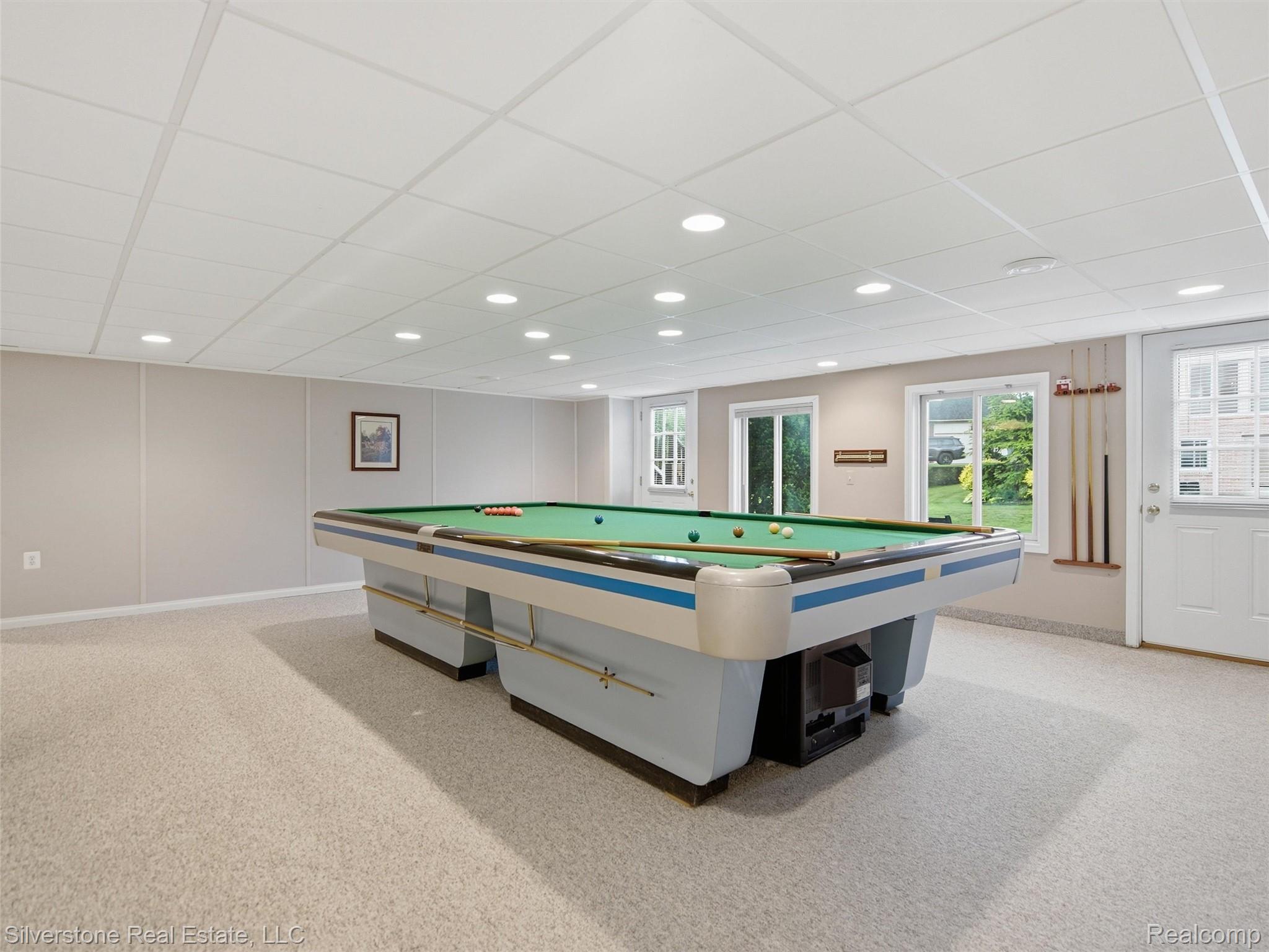 6577 Edith Court Troy, MI 48085 - Photo 46 of 61 Spacious recreation room featuring recessed lighting, a drop ceiling, light-colored carpeting, multiple windows, and a white paneled door