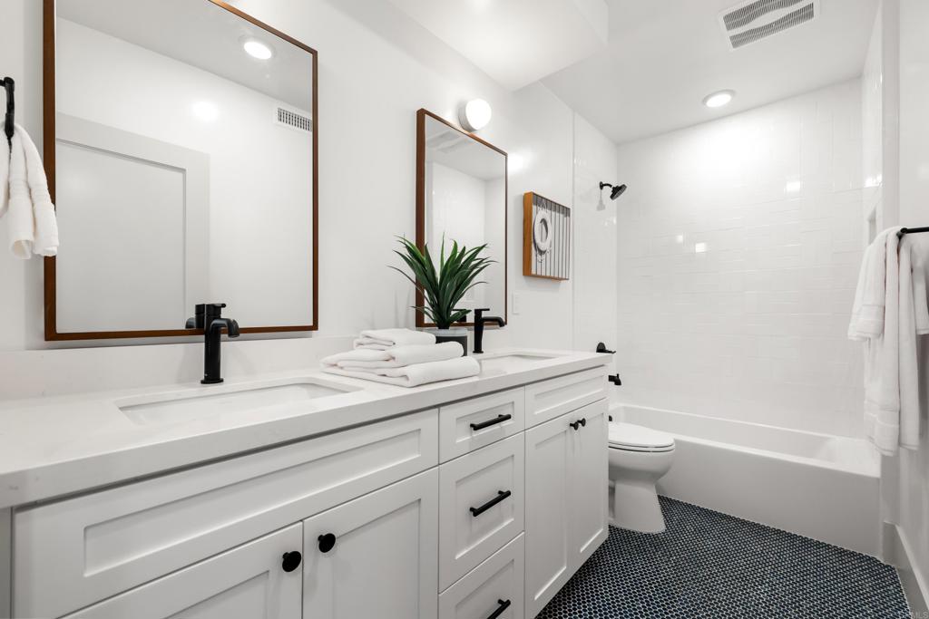 310-326 Chinquapin Avenue Carlsbad, CA 92008 - Photo 24 of 33 a bathroom with a double vanity sink a toilet and a bathtub