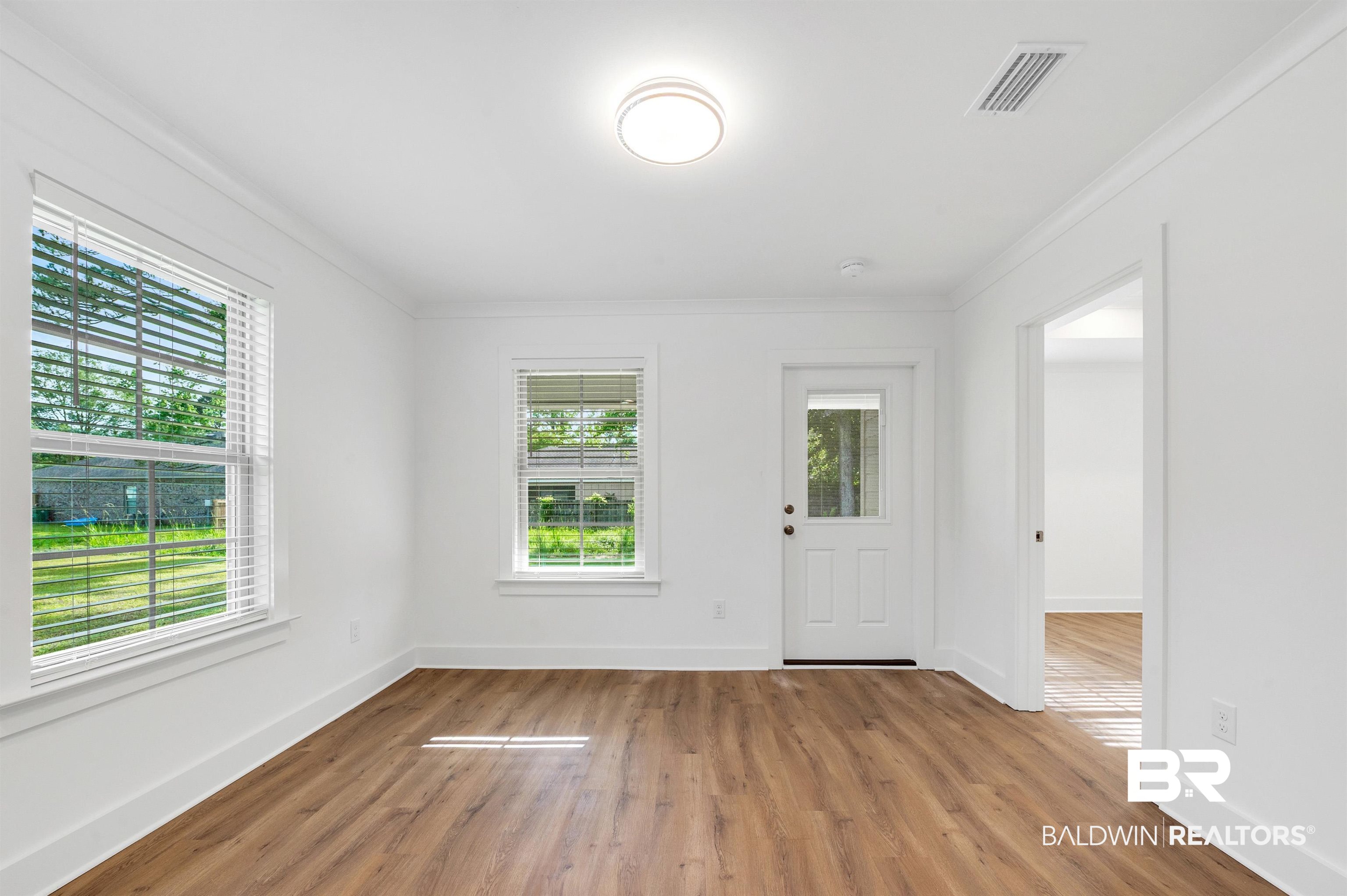 22045 8th Street Silverhill, AL 36576 - Photo 17 of 39 Dining area with plenty of natural light, wood finished floors, crown molding, and baseboards