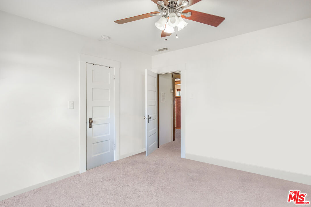 2715 Cridge Street Riverside, CA 92507 - Photo 17 of 25 an empty room with a chandelier fan and a ceiling fan