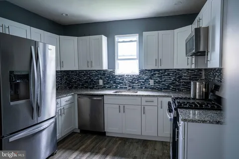 a kitchen with granite countertop stainless steel appliances and wooden cabinets