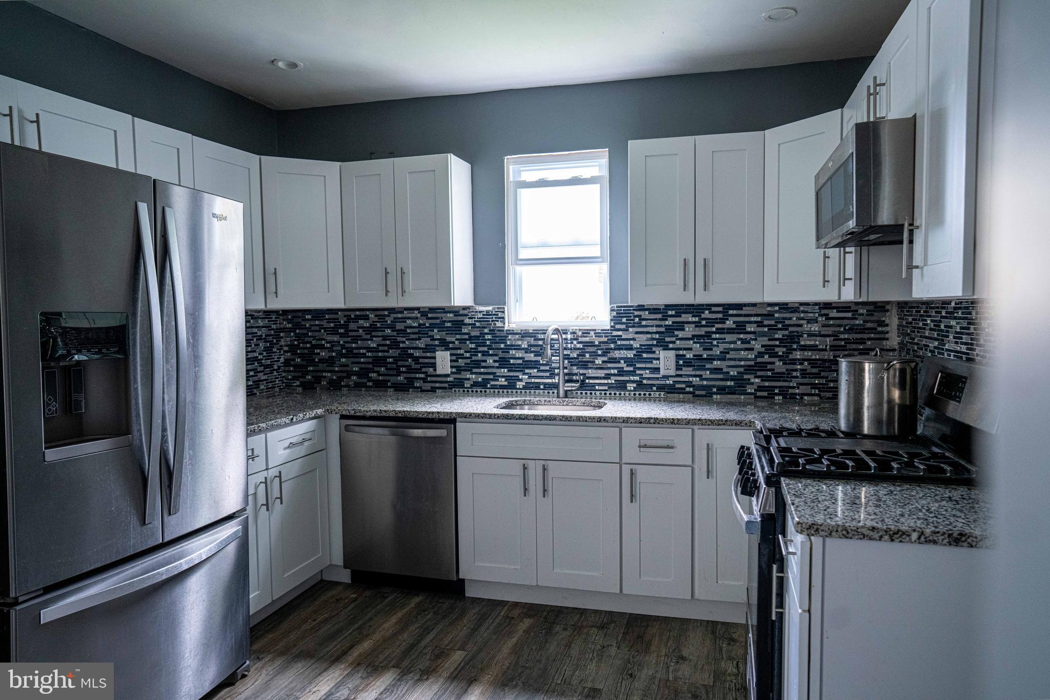 51 Lewis Avenue, Unit A Lansdowne, PA 19050 - Photo 14 of 28 a kitchen with stainless steel appliances granite countertop a stove a sink and a refrigerator