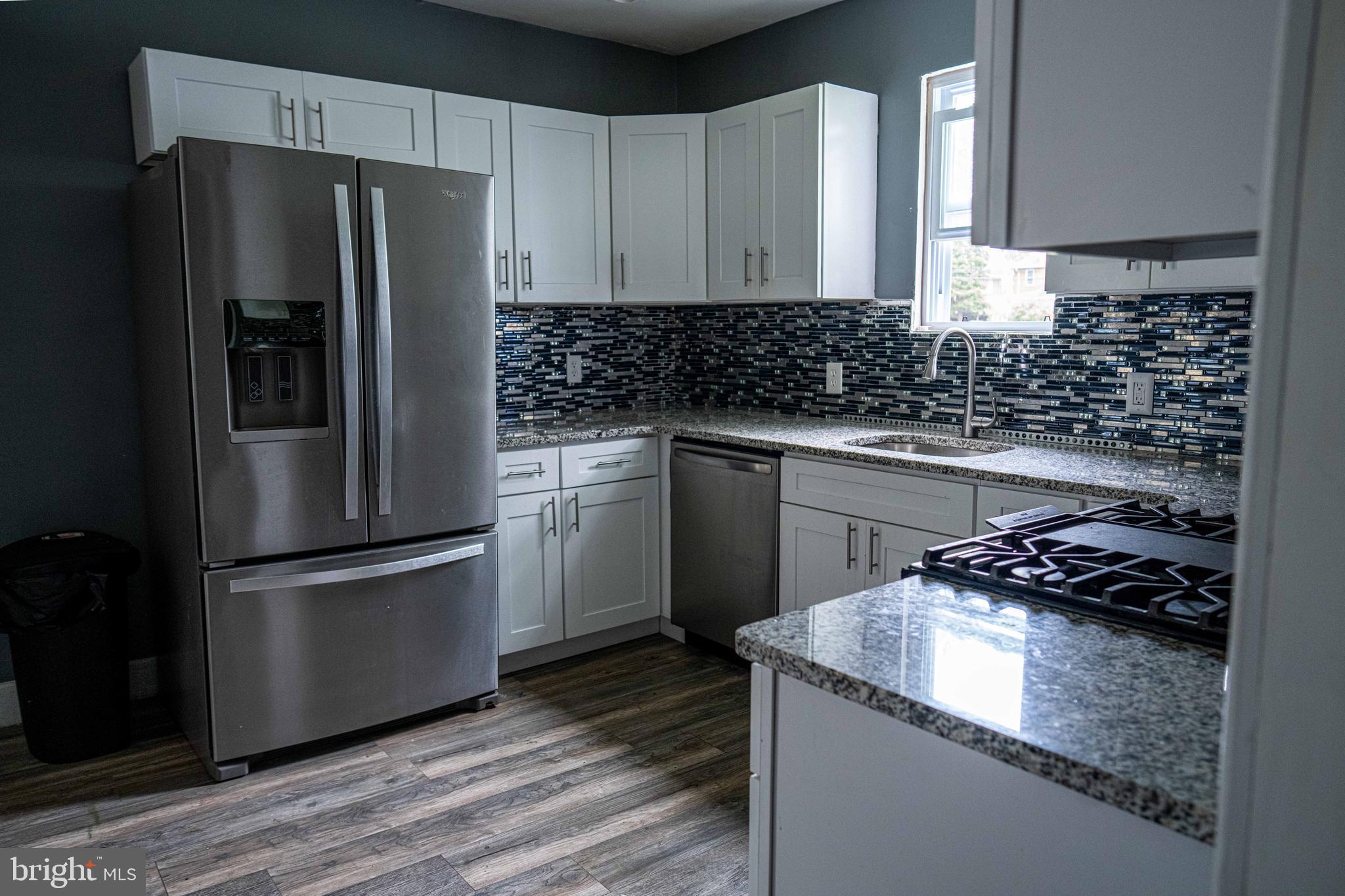 51 Lewis Avenue, Unit A Lansdowne, PA 19050 - Photo 15 of 28 a kitchen with granite countertop stainless steel appliances and wooden cabinets