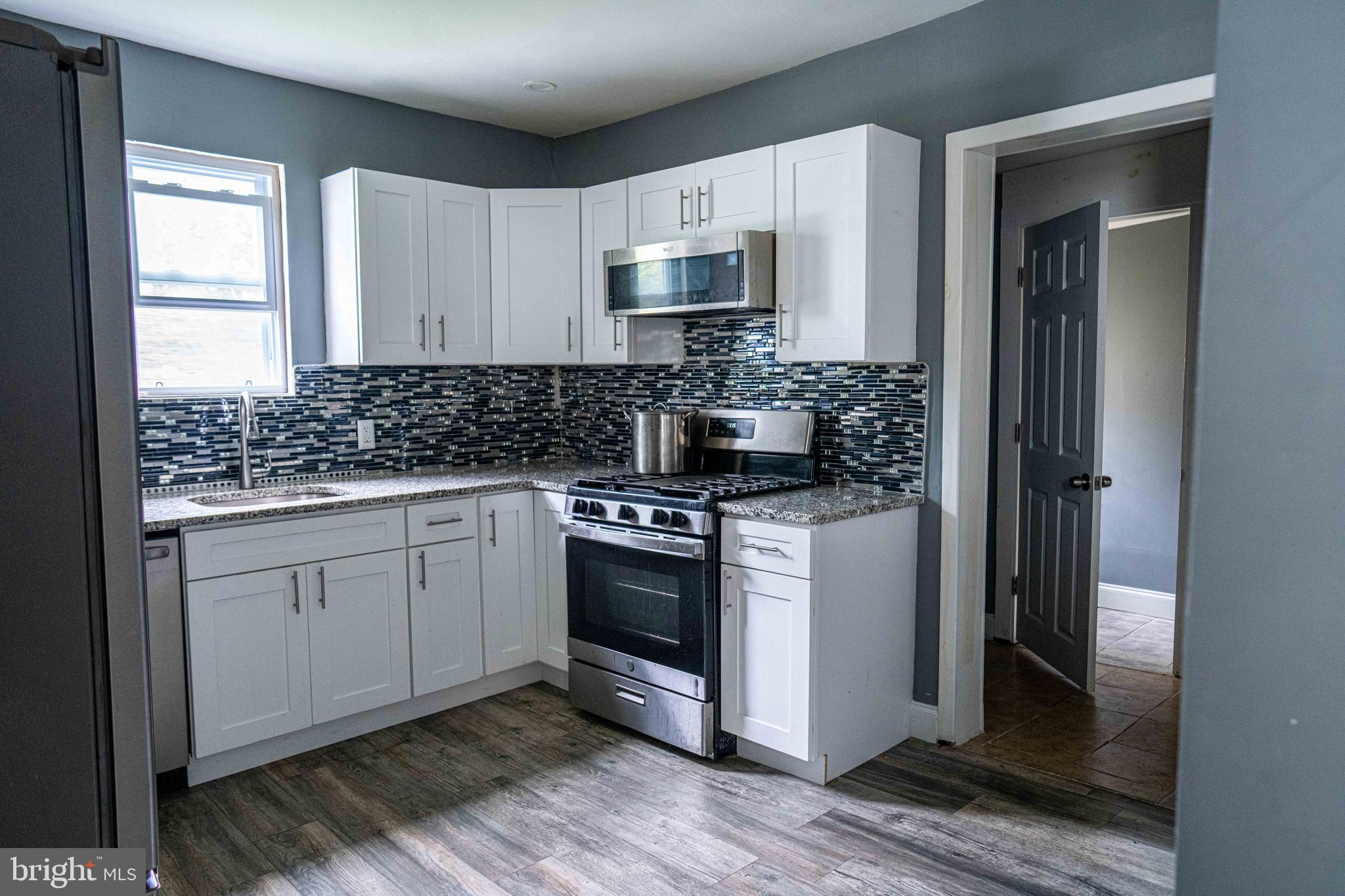 51 Lewis Avenue, Unit A Lansdowne, PA 19050 - Photo 16 of 28 a kitchen with stainless steel appliances granite countertop a stove a sink and a refrigerator