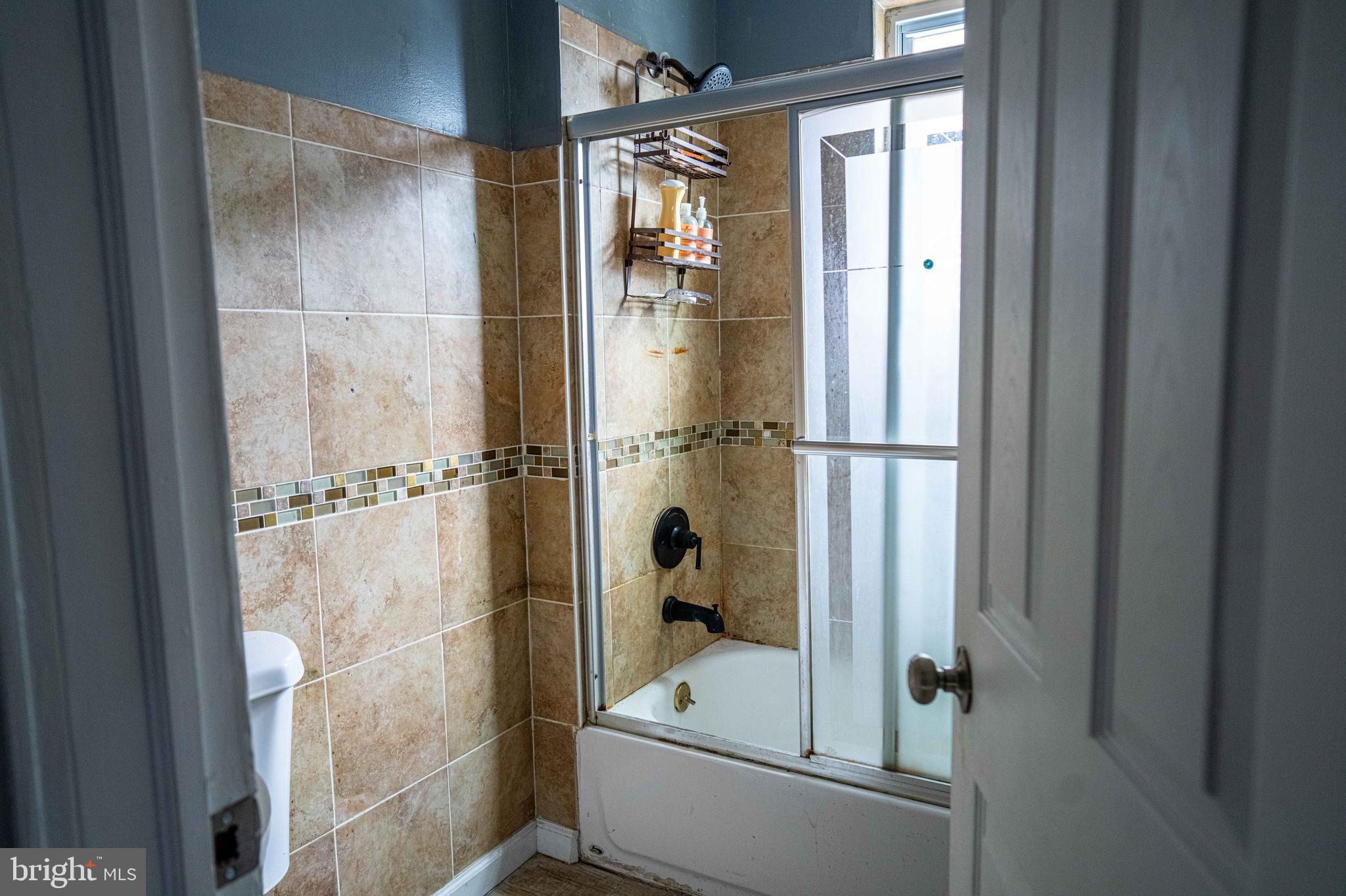 51 Lewis Avenue, Unit A Lansdowne, PA 19050 - Photo 23 of 28 a bathroom with a glass shower door