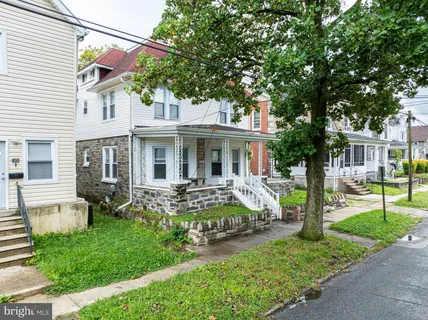 a view of a house with a yard and sitting area