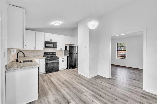 a kitchen with granite countertop a refrigerator stove and sink