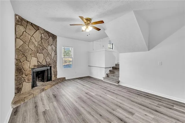 a view of empty room with wooden floor and fireplace