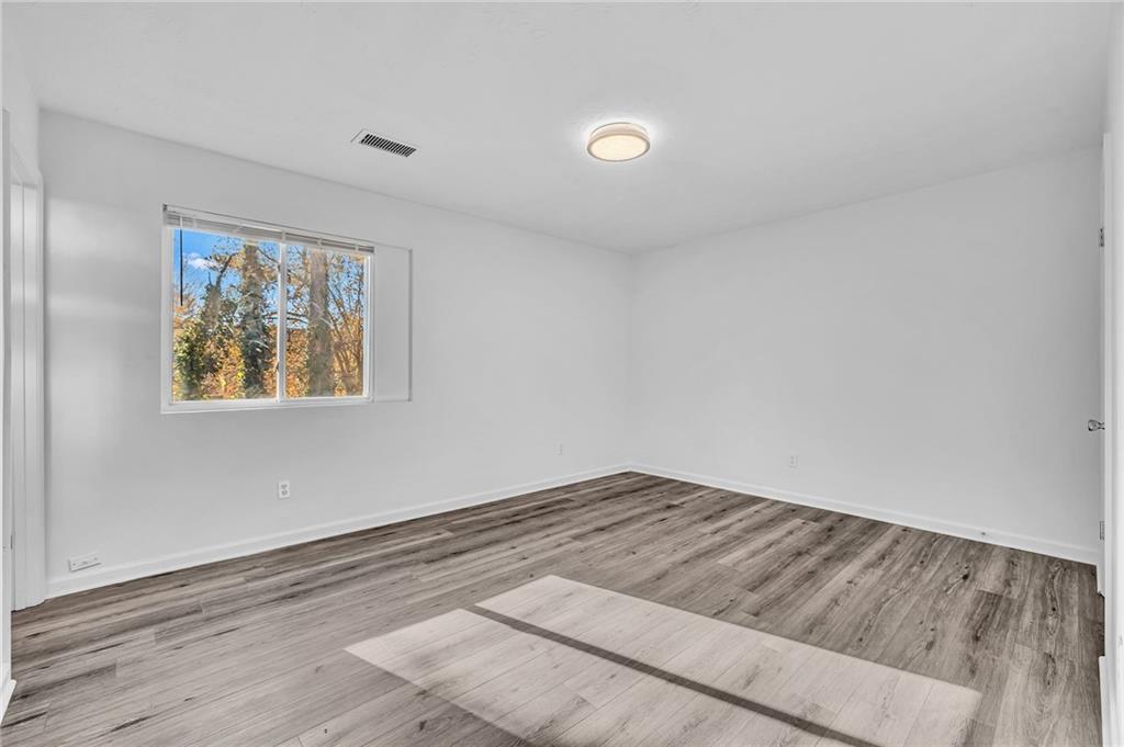 3959 Wood Path Drive Stone Mountain, GA 30083 - Photo 19 of 37 an empty room with wooden floor and windows