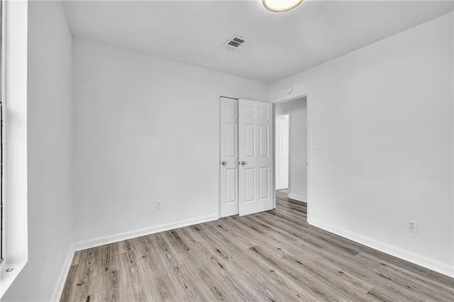 a view of an empty room with wooden floor