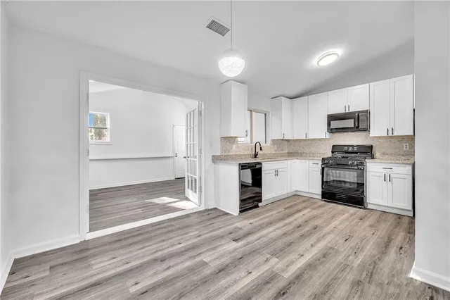 a kitchen with granite countertop a refrigerator stove and sink