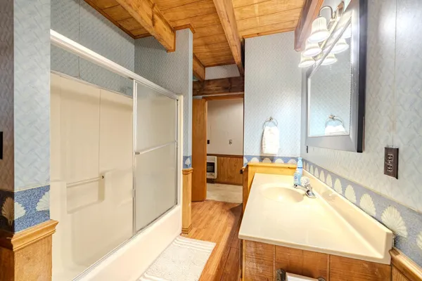 a bathroom with a tub sink and mirror