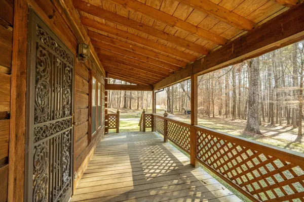 a view of a porch with wooden floor and furniture