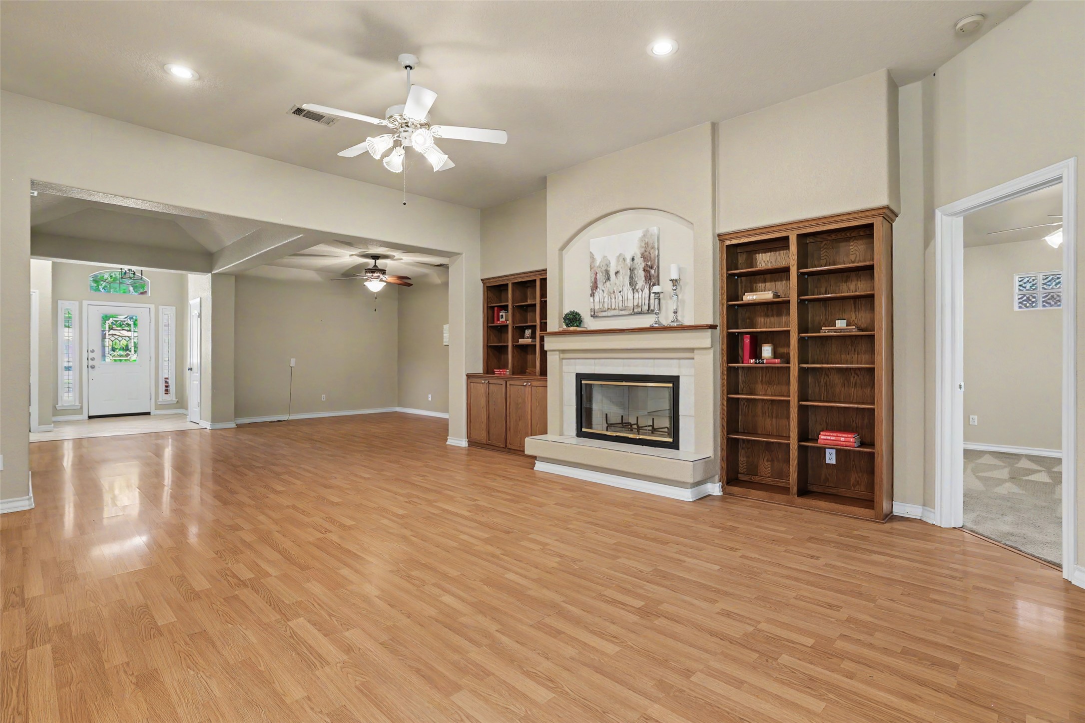 30107 Hamlet Circle Georgetown, TX 78628 - Photo 6 of 40 A welcoming entryway flows into a spacious living area featuring built-in shelving and a fireplace.