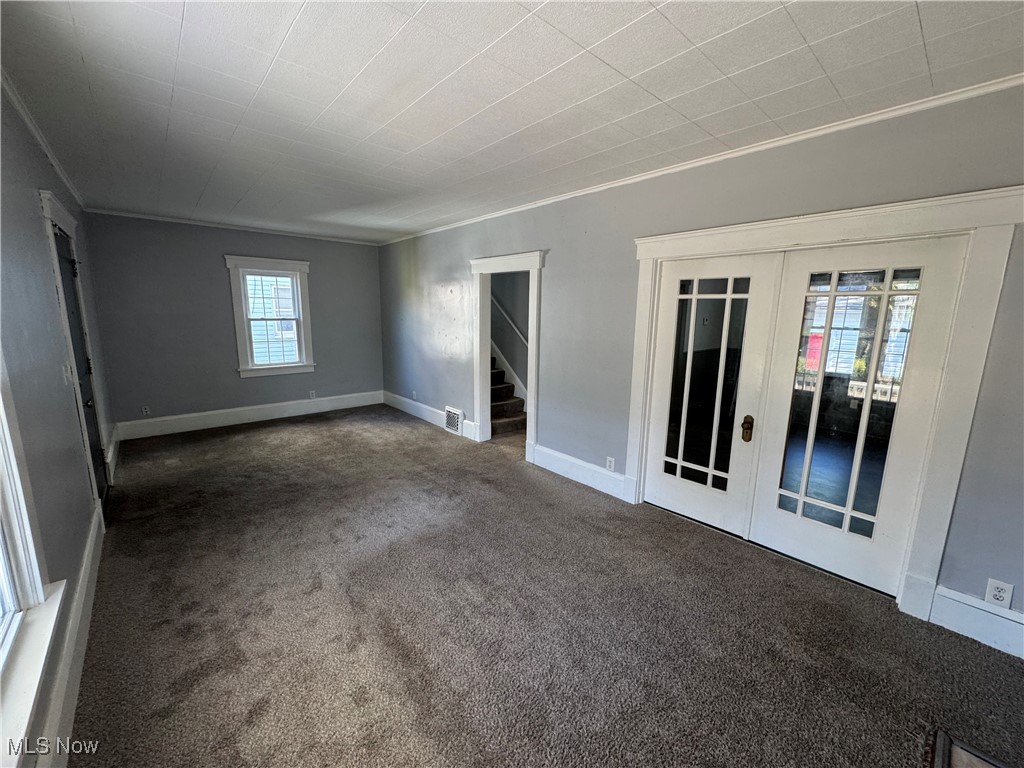 2425 7th Street Northwest Canton, OH 44708 - Photo 5 of 19 Unfurnished room with carpet flooring, stairway, crown molding, and french doors