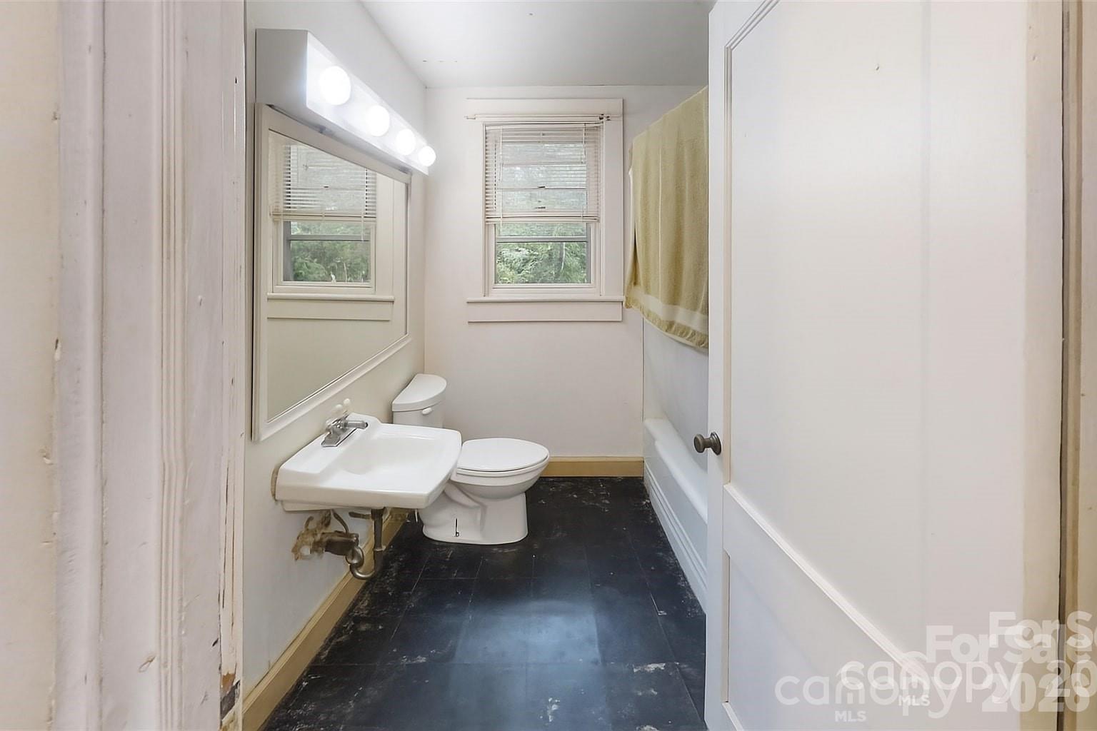 21 Maple Avenue Candler, NC 28715 - Photo 25 of 28 a bathroom with a sink a toilet a tub and a window