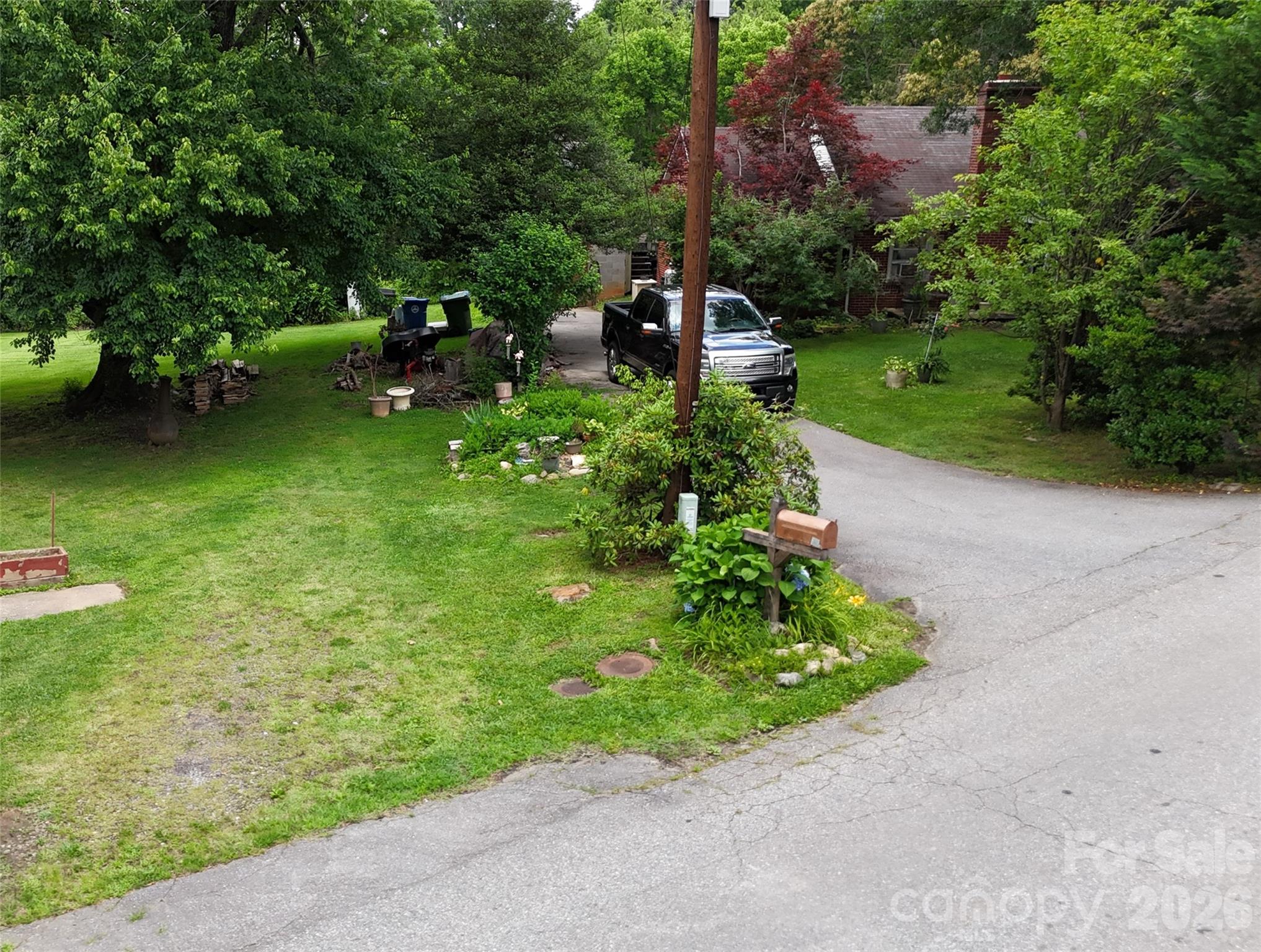 21 Maple Avenue Candler, NC 28715 - Photo 3 of 28 a backyard of a house with a garden and deck