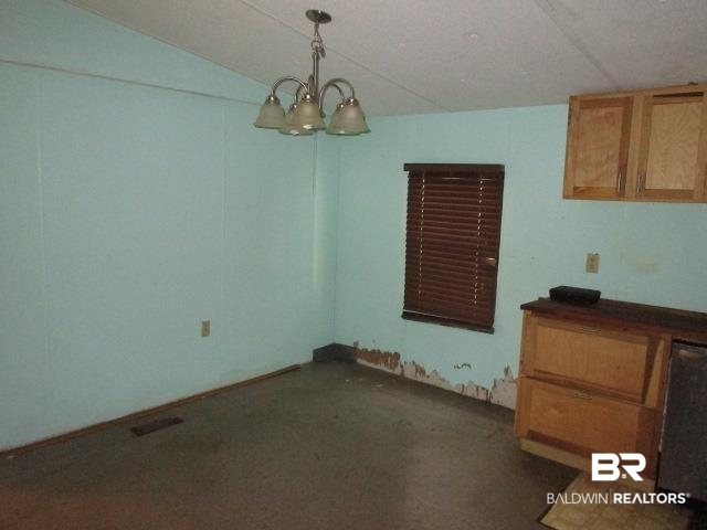 20705 Greek Cemetery Road Robertsdale, AL 36567 - Photo 8 of 25 Unfurnished dining area with a chandelier and dark colored carpet