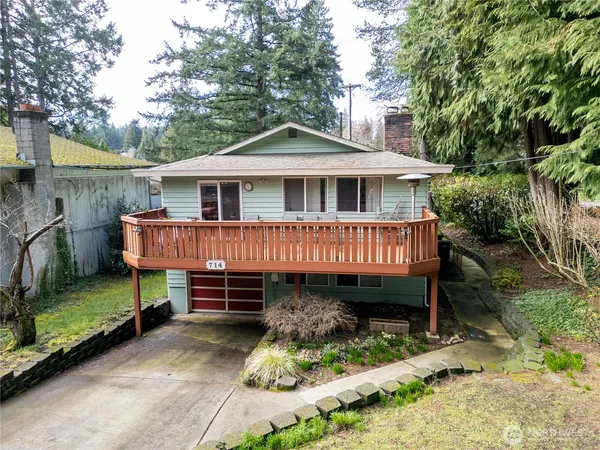 a view of a house with wooden deck and backyard