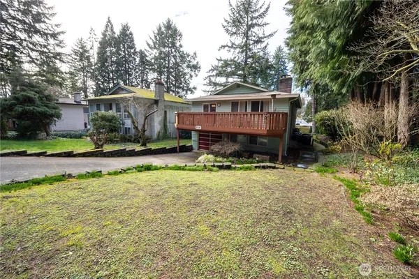 a front view of a house with a yard and trees