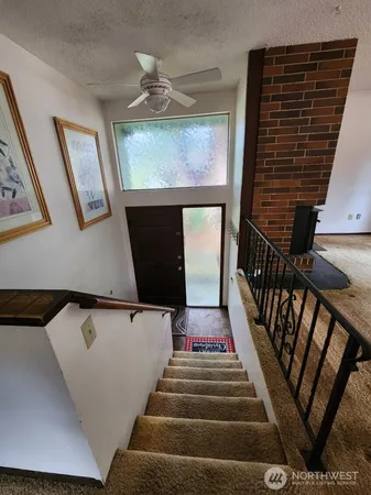 a view of staircase with railing and white walls