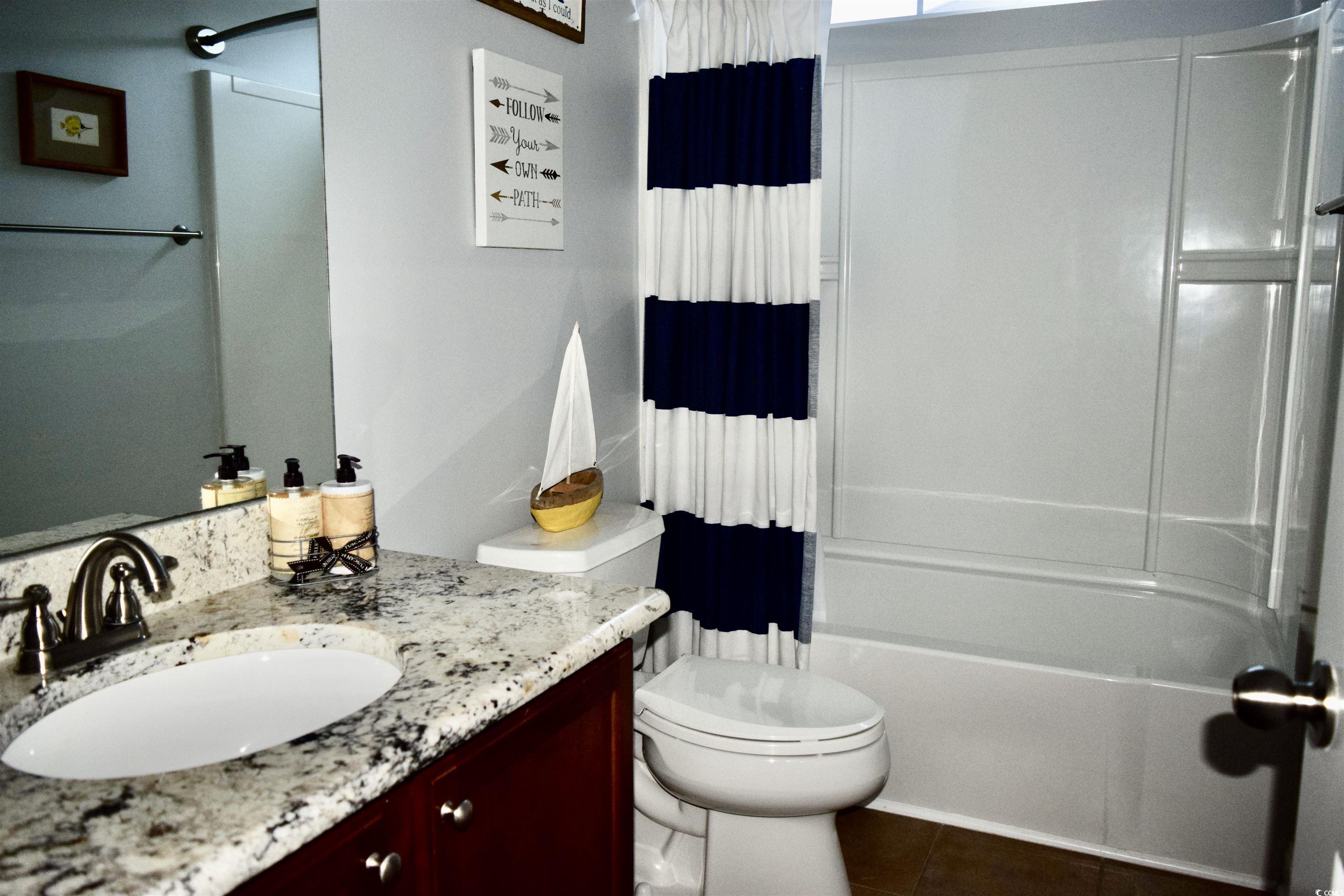 324 Oak Haven Drive Murrells Inlet, SC 29576 - Photo 26 of 38 Full bathroom with shower / bath combo, vanity, and dark tile patterned flooring
