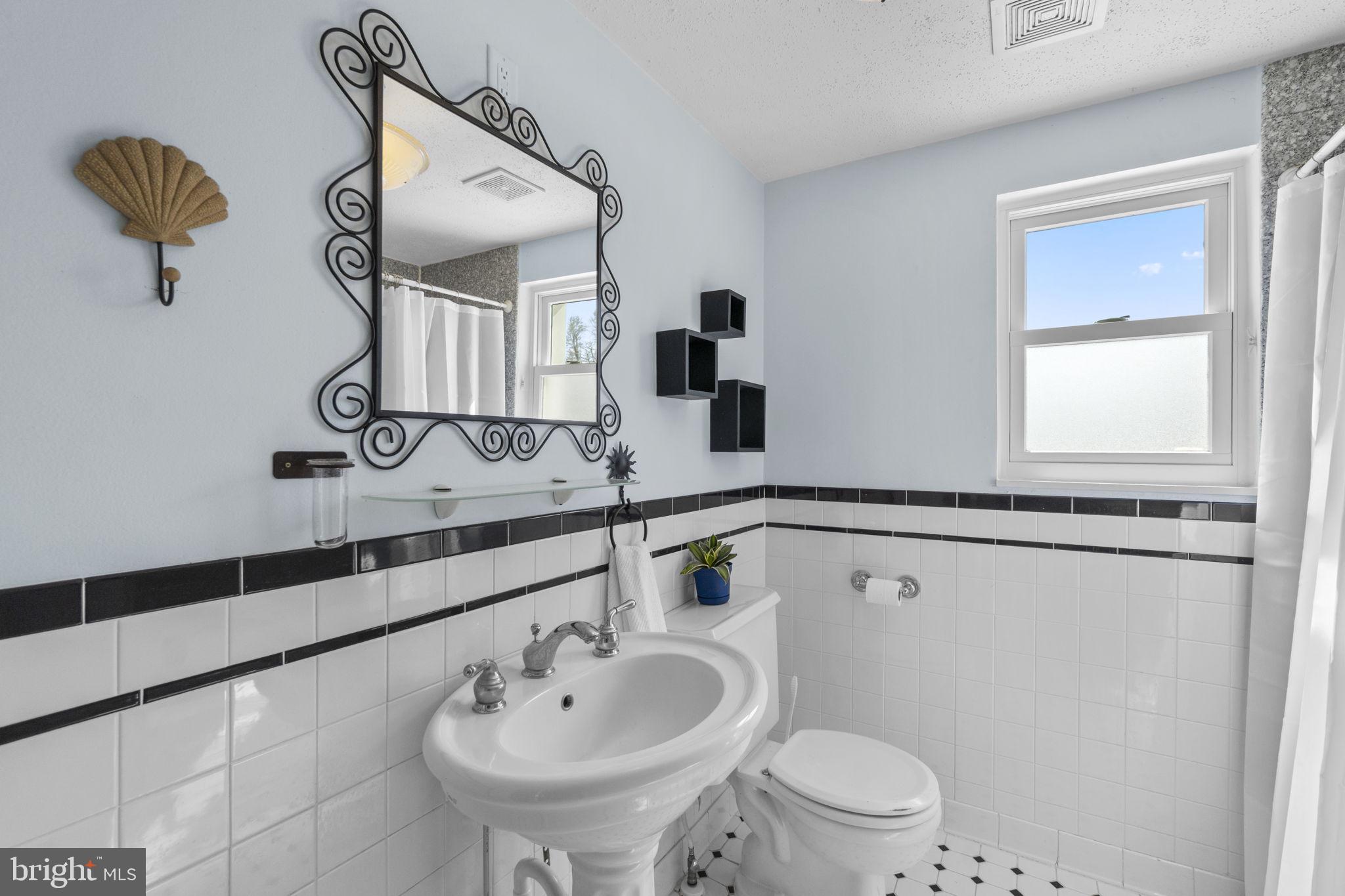 5718 Shookstown Road Frederick, MD 21702 - Photo 16 of 32 a bathroom with a sink a mirror and a toilet