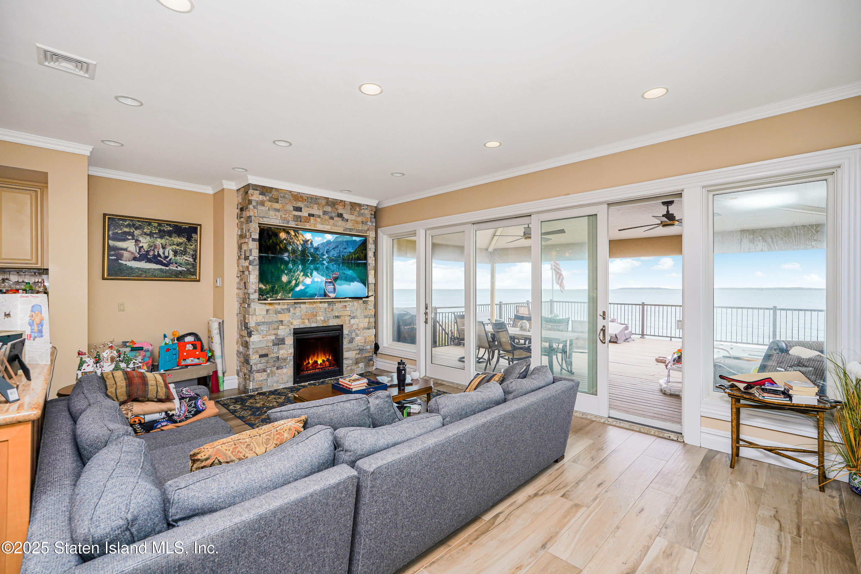 44 Zephyr Avenue Staten Island, NY 10312 - Photo 4 of 54 a living room with furniture a fireplace and a floor to ceiling window
