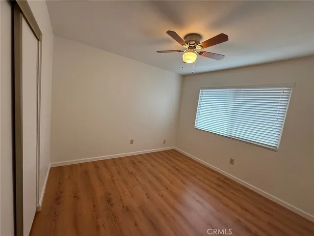 a view of a room with a ceiling fan and wooden floor