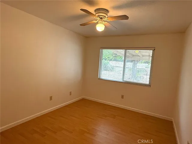 an empty room with a window and a fan