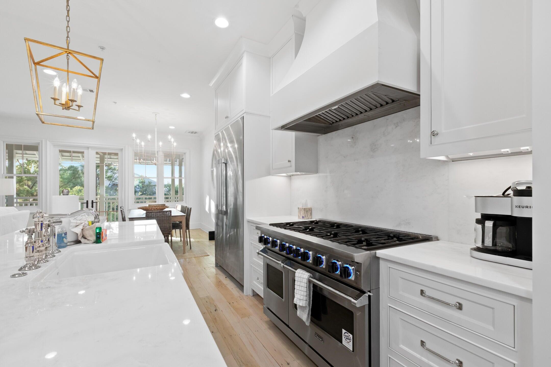 23 Johnstown Lane Inlet Beach, FL 32461 - Photo 26 of 35 a kitchen with stainless steel appliances granite countertop a stove a sink dishwasher and white cabinets with wooden floor