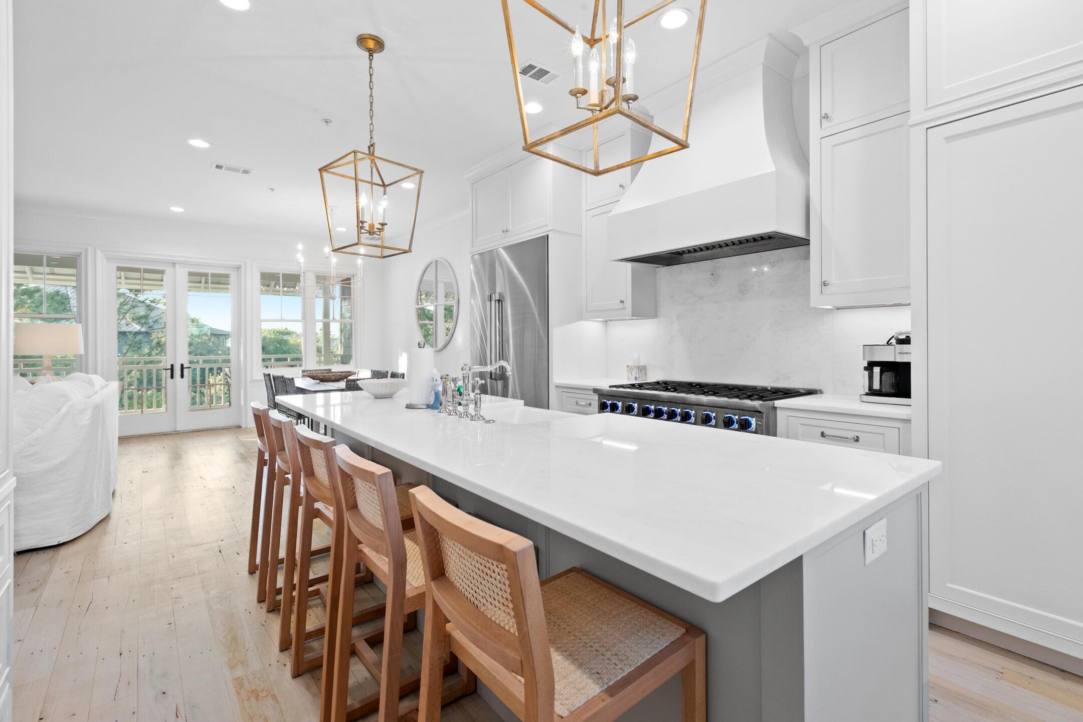 23 Johnstown Lane Inlet Beach, FL 32461 - Photo 5 of 35 a kitchen with stainless steel appliances a table chairs and chandelier