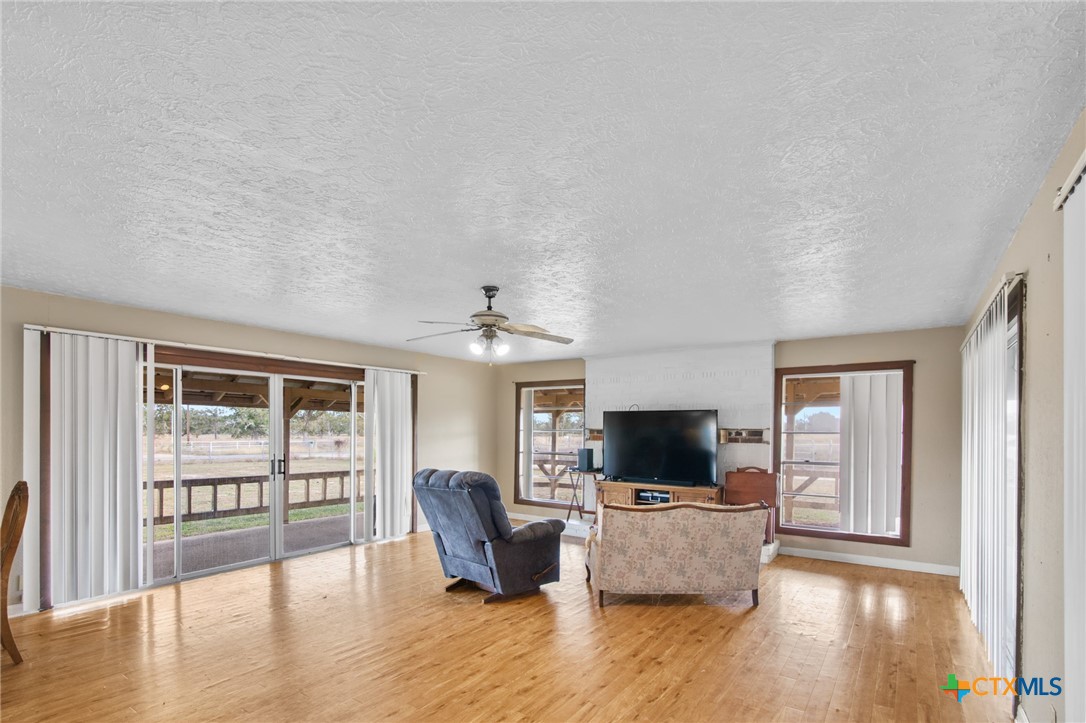 1720 Lower Mission Valley Road Victoria, TX 77905 - Photo 13 of 30 a living room with furniture a flat screen tv and a floor to ceiling window