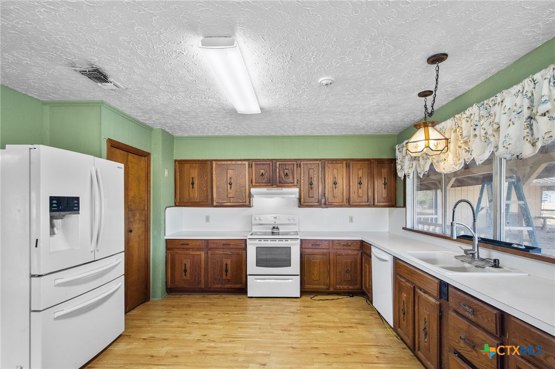 1720 Lower Mission Valley Road Victoria, TX 77905 - Photo 9 of 30 a kitchen with stainless steel appliances a sink a stove a microwave a center island and cabinets