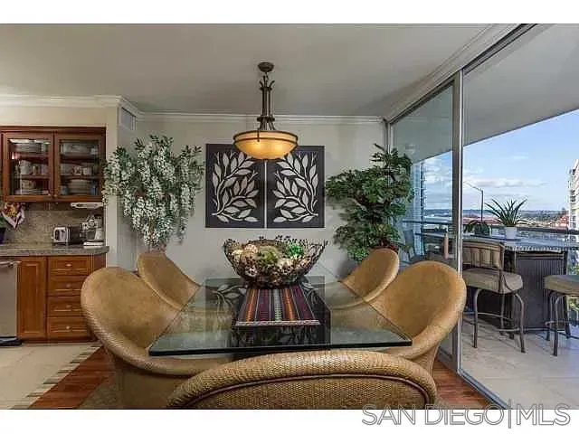 a dining room with furniture a chandelier and kitchen view