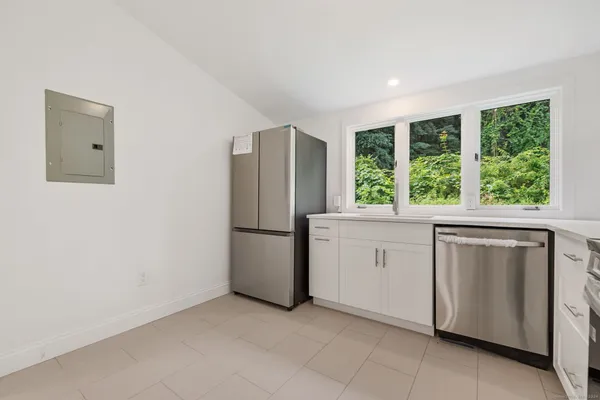 a kitchen with windows and refrigerator