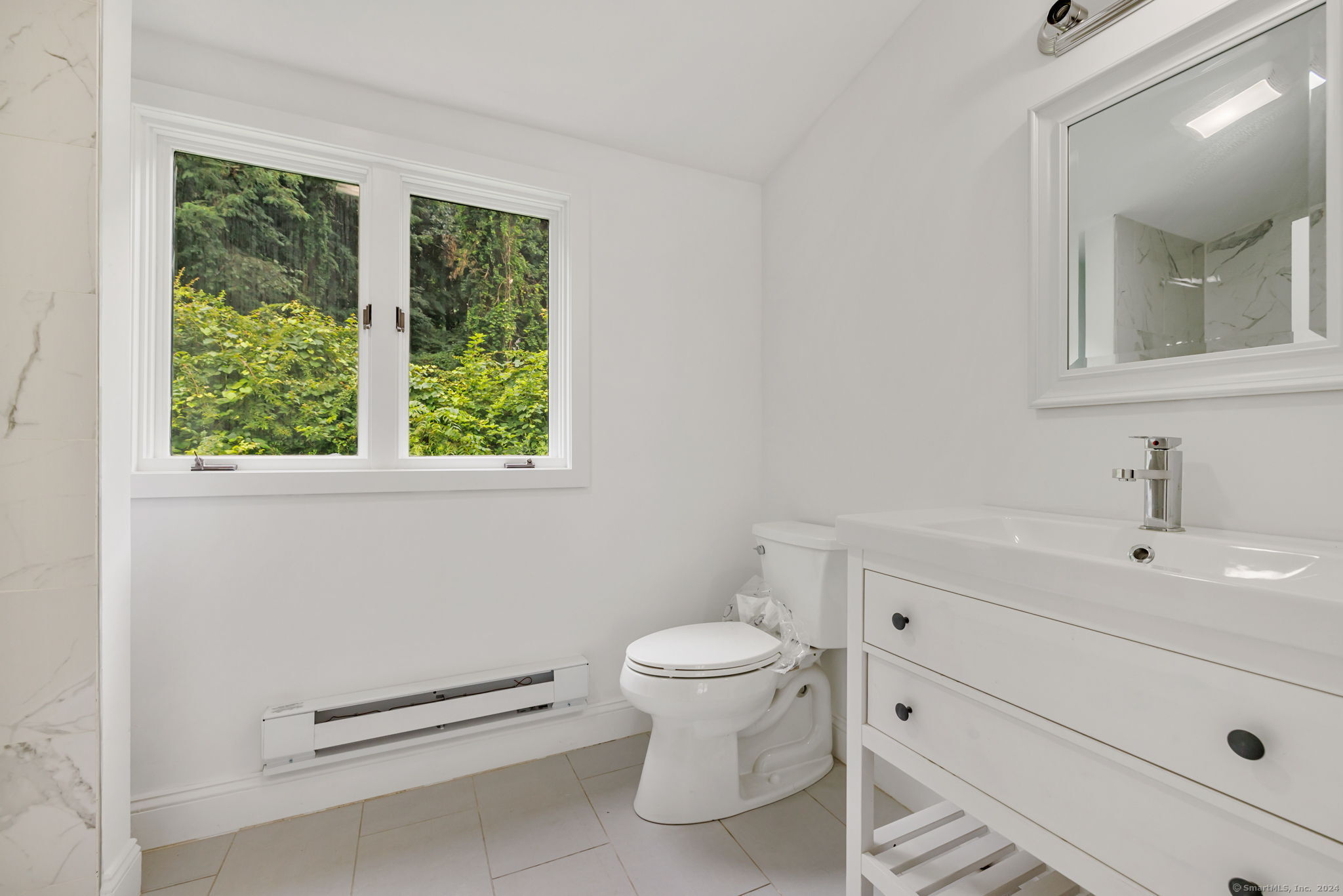 529 Danbury Road, Unit A Wilton, CT 06897 - Photo 21 of 23 a bathroom with a toilet a sink and a mirror