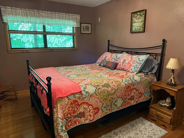 a bed sitting in a bedroom next to a window