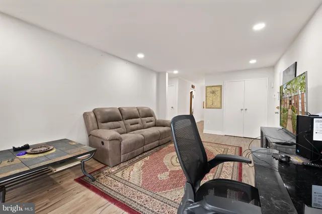 a living room with furniture a flat screen tv and a window