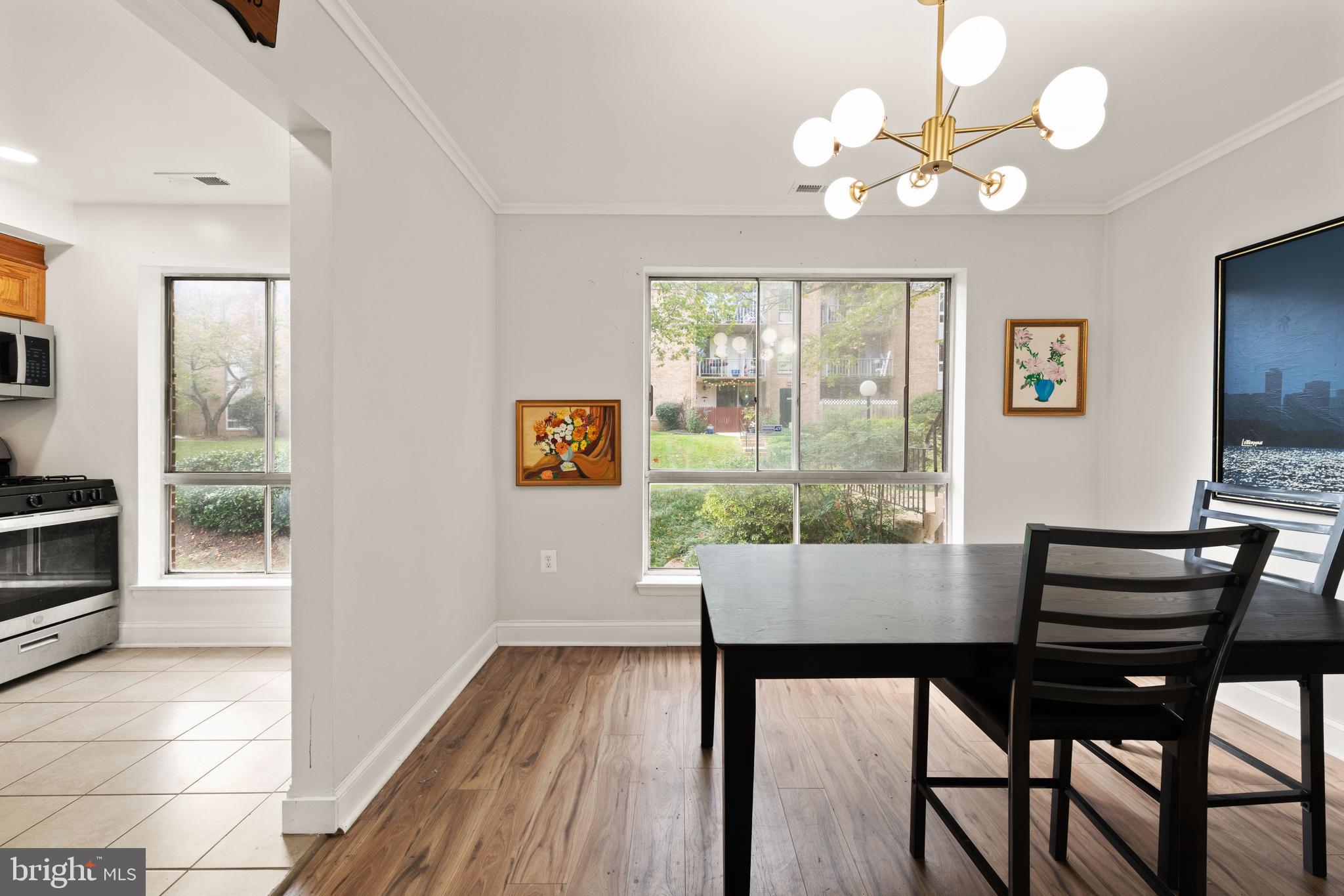 3914 Bel Pre Road, Unit 3914 Silver Spring, MD 20906 - Photo 4 of 16 a dining room with wooden floor a chandelier a wooden table and chairs