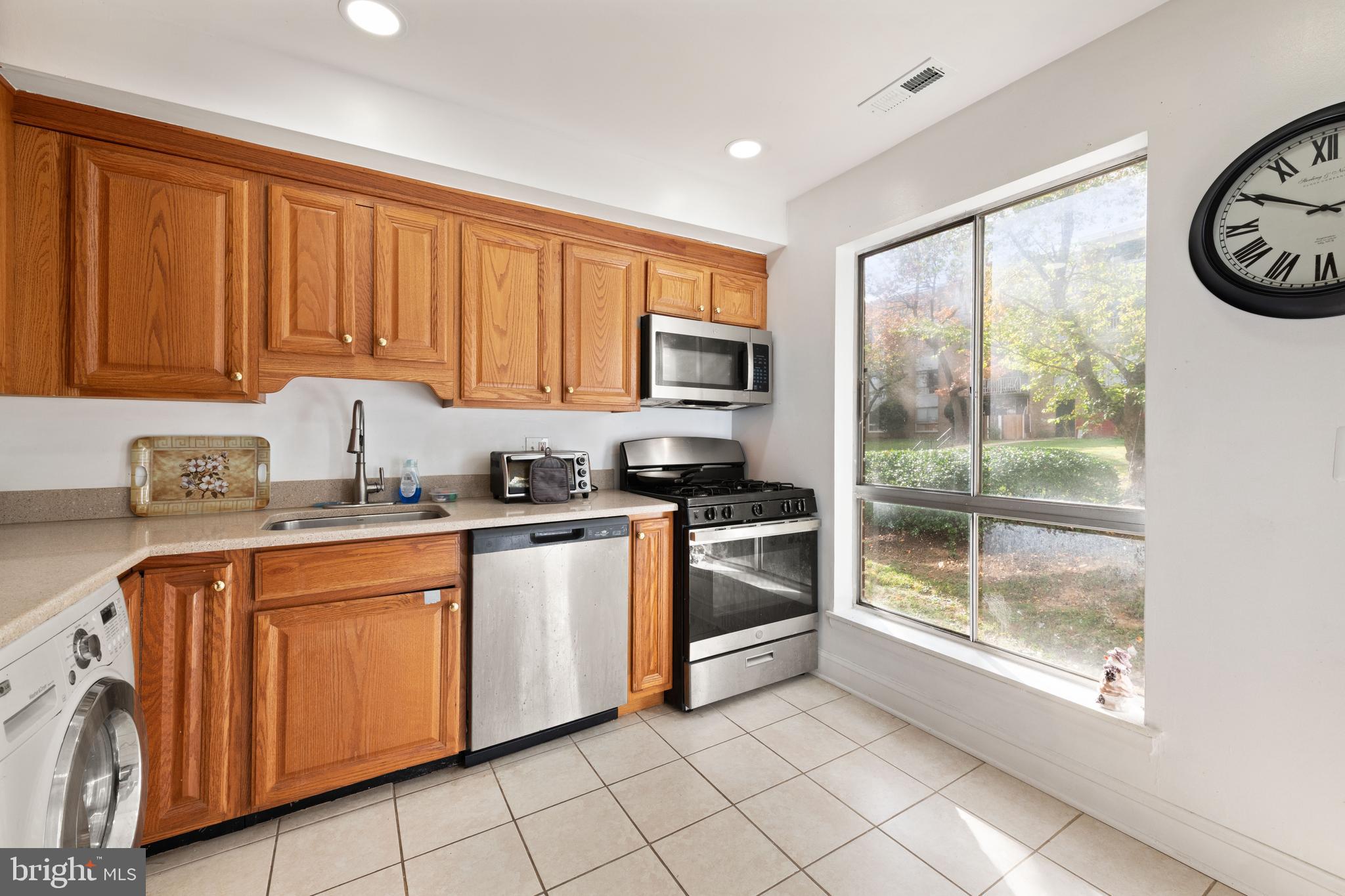 3914 Bel Pre Road, Unit 3914 Silver Spring, MD 20906 - Photo 7 of 16 a kitchen with granite countertop a stove top oven sink and cabinets